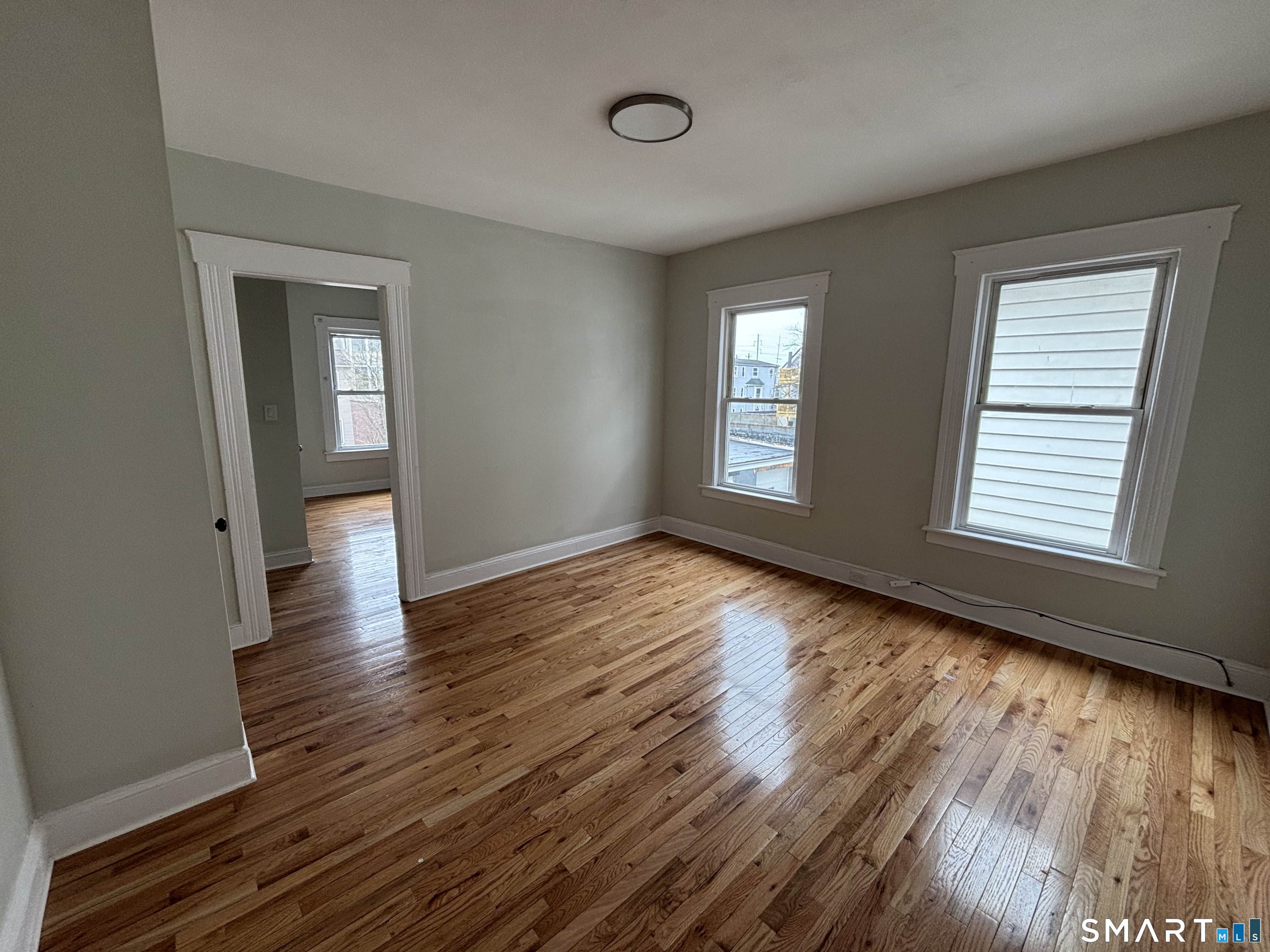 241 Lewis Street Bridgeport, CT 06605 - Photo 9 of 33 a view of an empty room with wooden floor and a window