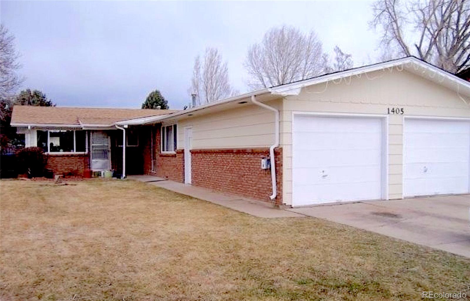 1405 East 16th Street, Unit B Loveland, CO 80538 - Photo 1 of 14 a view of a house with a yard and garage