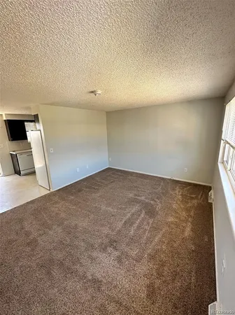 an empty room with a wooden floor and windows