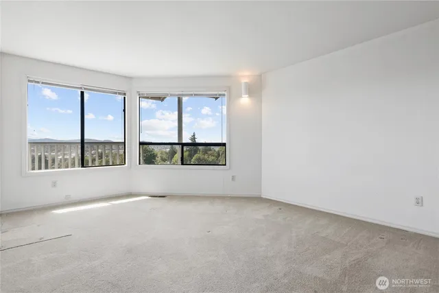 an empty room with floor to ceiling window and couch