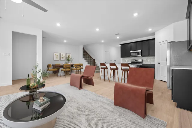 a living room with furniture kitchen view and a wooden floor