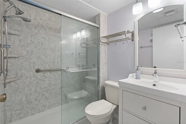 a bathroom with a sink a mirror toilet and shower