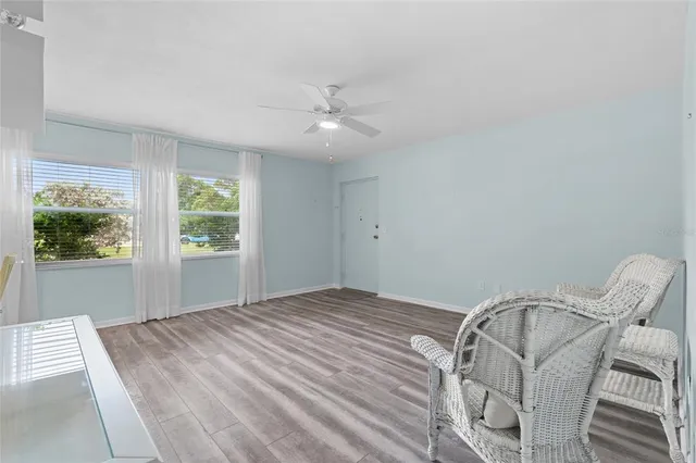 a view of a bedroom with wooden floor fan and windows