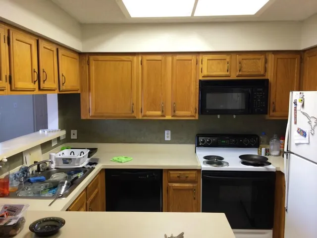a white refrigerator freezer and a stove sitting inside of a kitchen