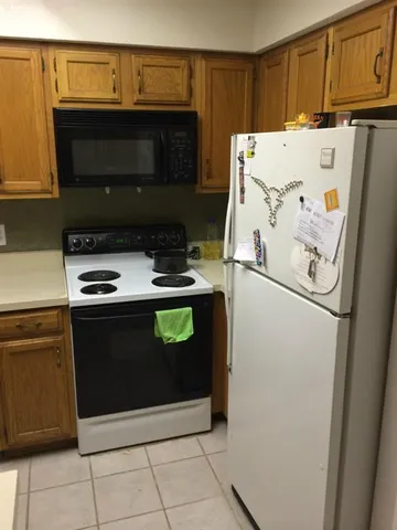 a bedroom with a bed and a lamp on dresser