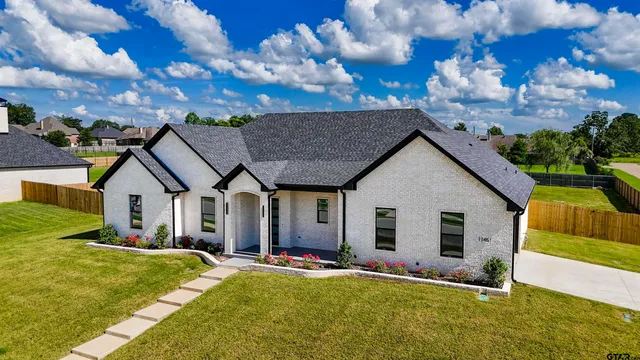 a view of a house with backyard and sitting area