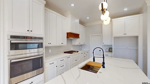 a kitchen with kitchen island a sink stainless steel appliances and cabinets