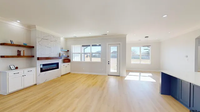 a kitchen with white cabinets and a wooden floor