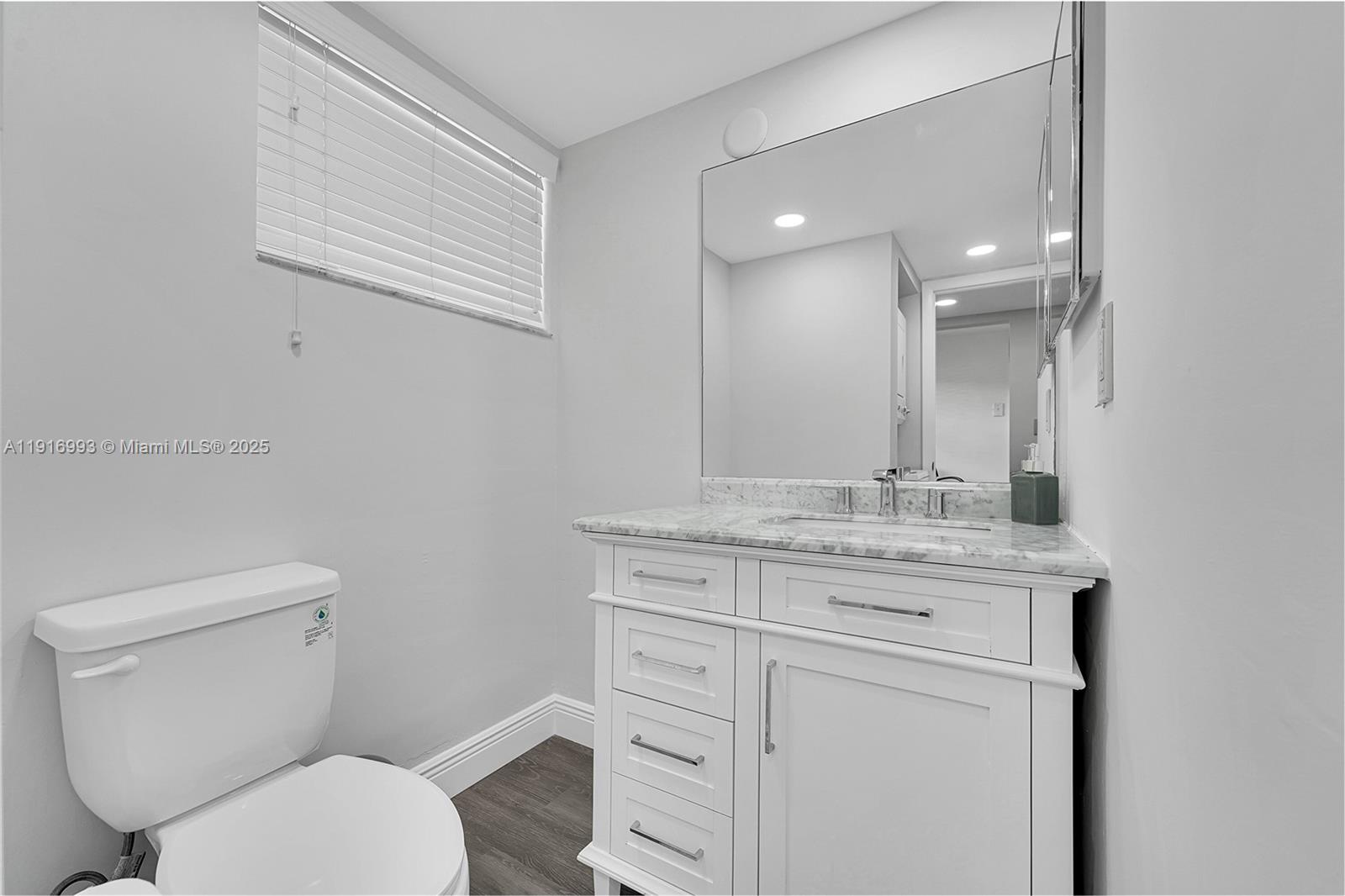 8405 Northwest 61st Street, Unit D207 Tamarac, FL 33321 - Photo 11 of 28 a bathroom with a granite countertop toilet sink and mirror