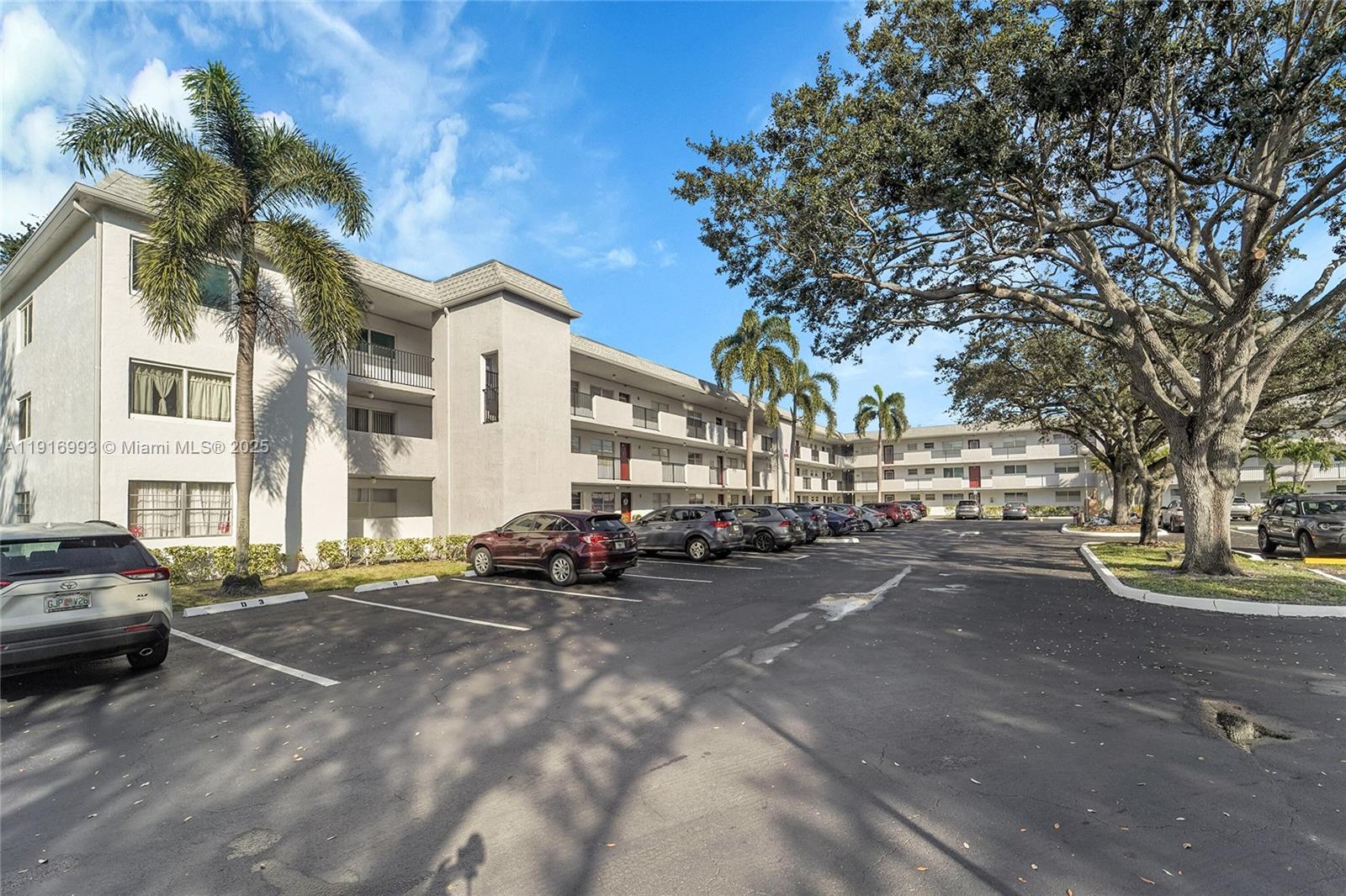 8405 Northwest 61st Street, Unit D207 Tamarac, FL 33321 - Photo 18 of 28 a city street lined with buildings and cars
