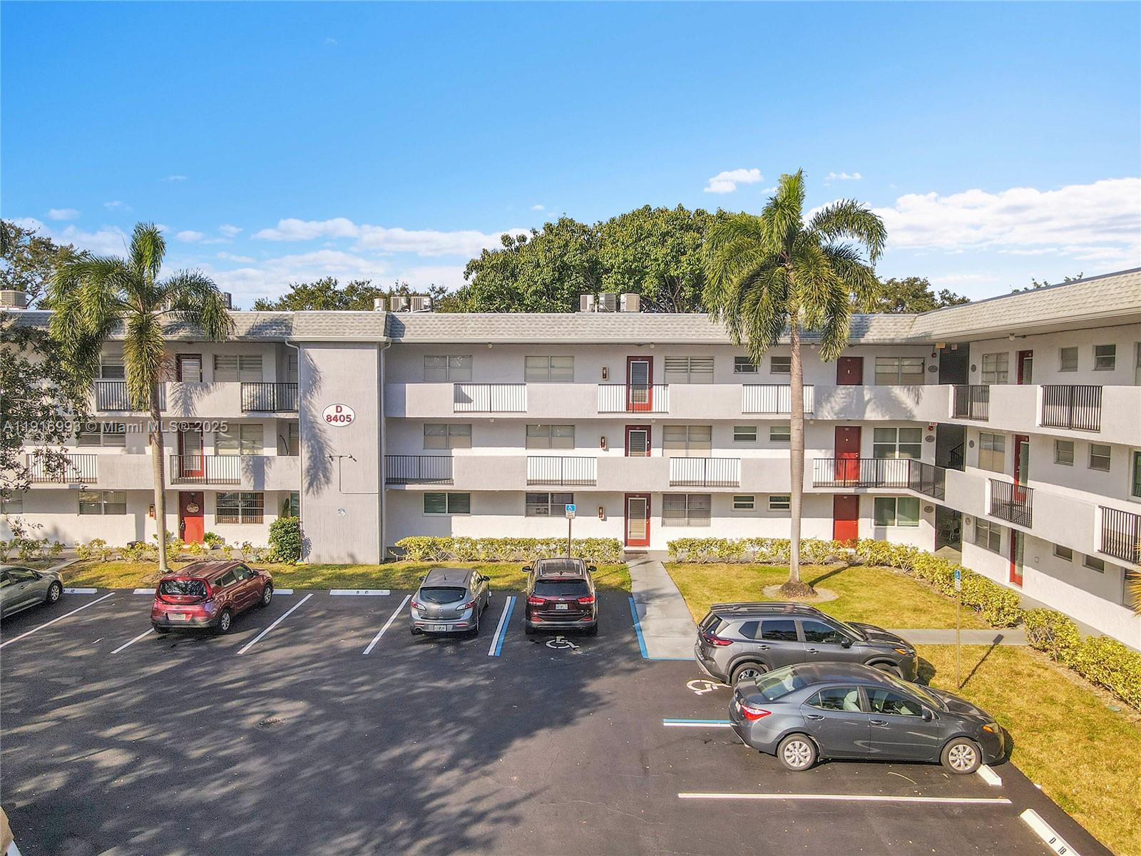 8405 Northwest 61st Street, Unit D207 Tamarac, FL 33321 - Photo 28 of 28 a view of a building with cars parked in front of it