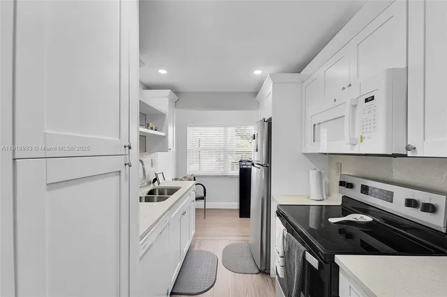 a kitchen that has a sink a stove and refrigerator