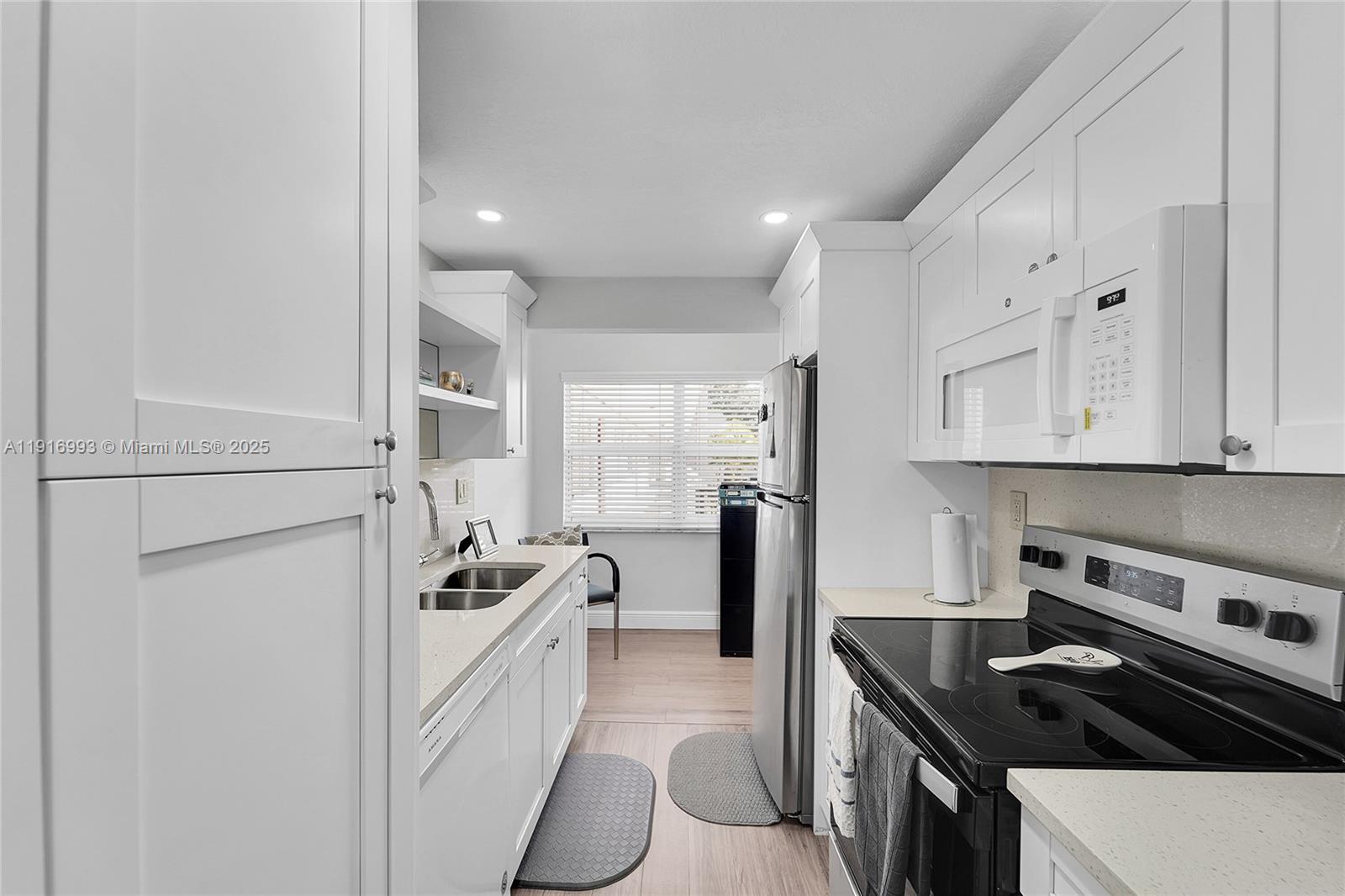 8405 Northwest 61st Street, Unit D207 Tamarac, FL 33321 - Photo 3 of 28 a kitchen that has a sink a stove and refrigerator