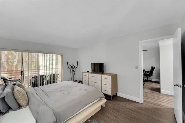 a bedroom with a bed and large windows