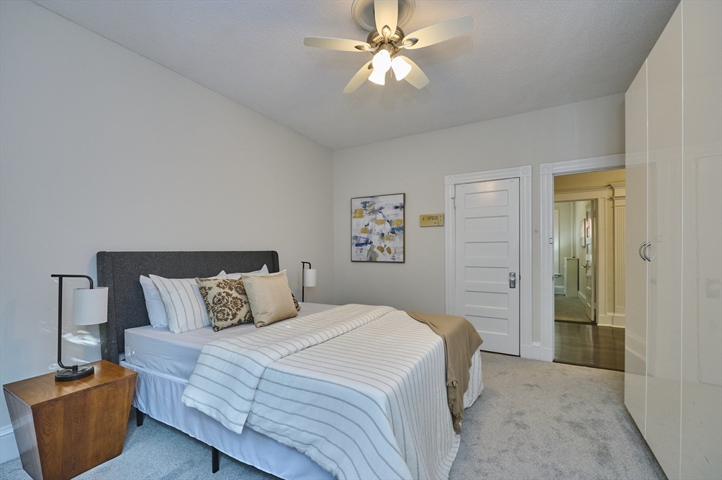 5 Auburn Court, Unit 1 Brookline, MA 02446 - Photo 14 of 22 a bedroom with a bed and a chandelier