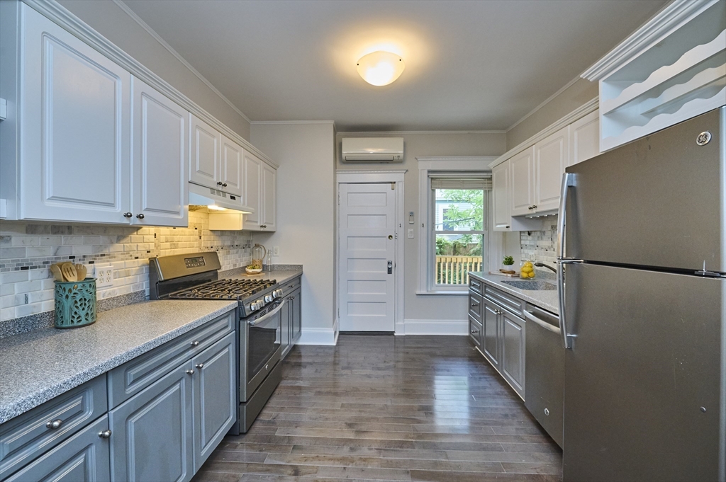 5 Auburn Court, Unit 1 Brookline, MA 02446 - Photo 7 of 22 a kitchen with a refrigerator a stove a sink and wooden floor