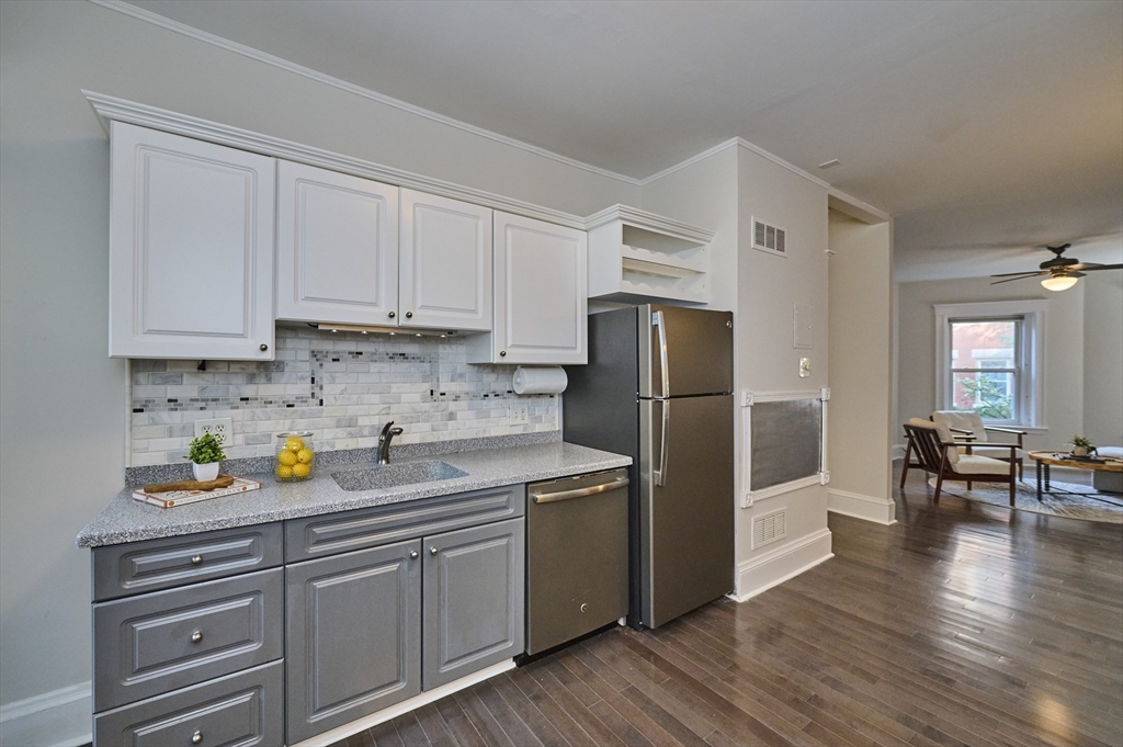 5 Auburn Court, Unit 1 Brookline, MA 02446 - Photo 8 of 22 a kitchen with stainless steel appliances white cabinets and wooden floors