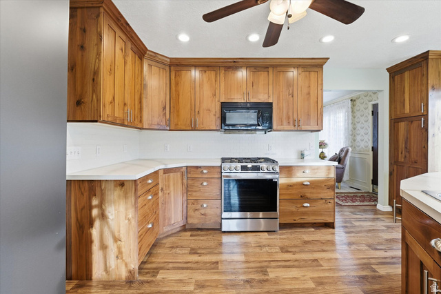 165 Main Street Georgetown, ID 83239 - Photo 13 of 50 Kitchen with gas stove, light wood-style flooring, brown cabinetry, black microwave, and light countertops