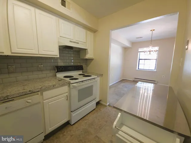 a kitchen with granite countertop white cabinets and white appliances