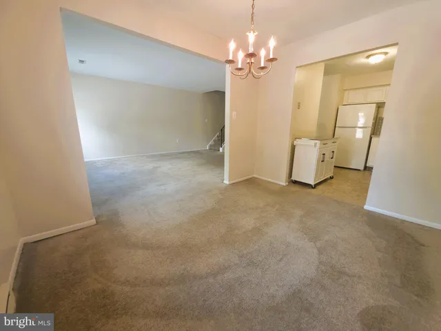 a view of a big room with a chandelier fan and windows