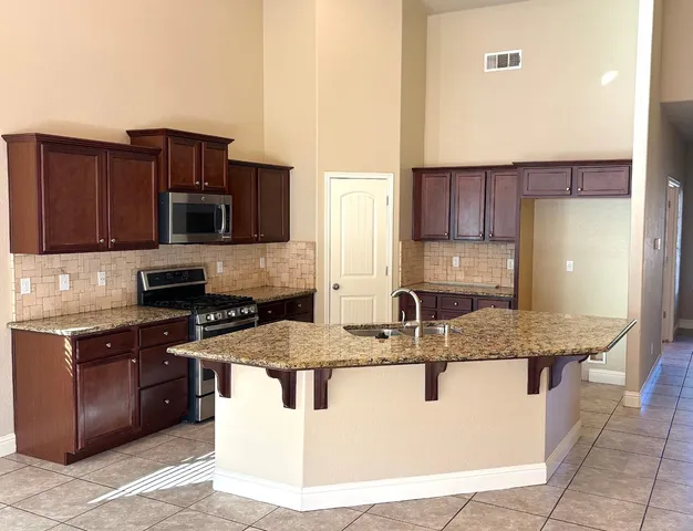 a kitchen with stainless steel appliances granite countertop a counter top and a refrigerator