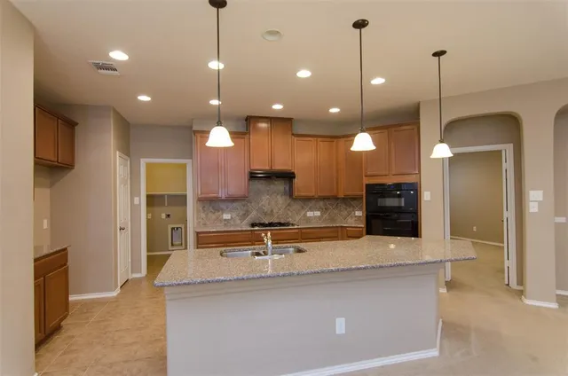 a view of kitchen with kitchen island wooden floor appliances and living room