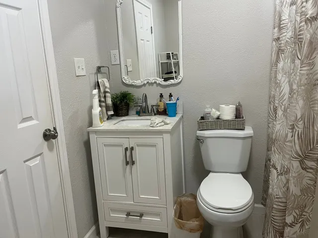 a bathroom with a sink a toilet and a mirror