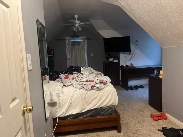 a bedroom with a bed and a flat tv screen