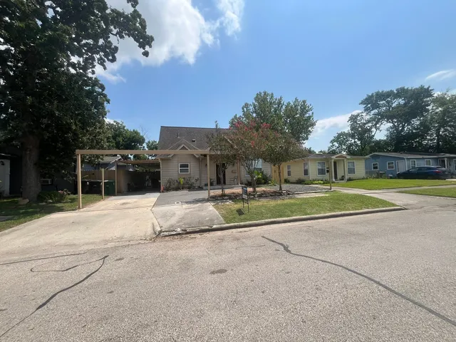 a view of a house with a big yard and large trees
