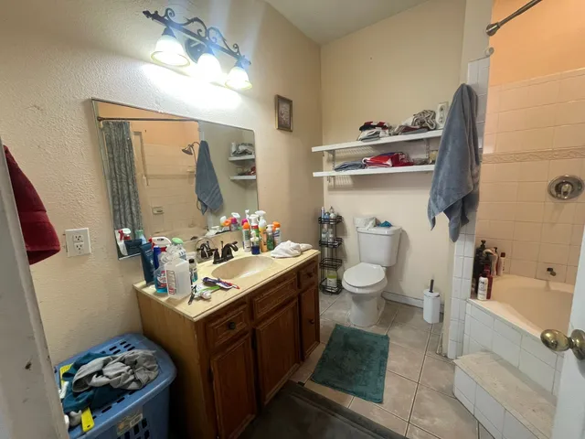 a bathroom with a sink mirror vanity and toilet