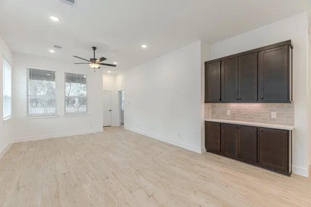 a view of an empty room with a cabinet and a window