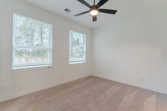 an empty room with a window and a fan
