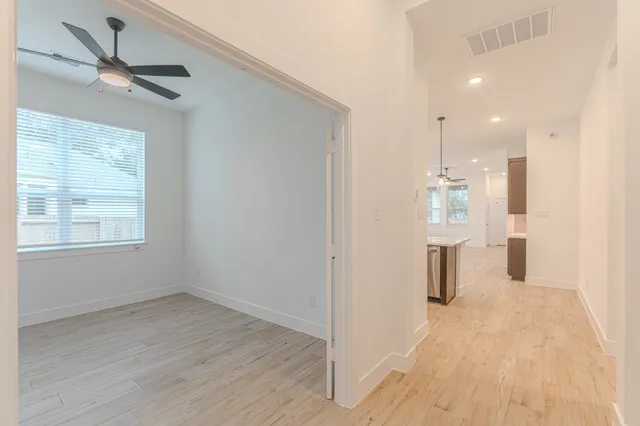 a view of empty room with wooden floor