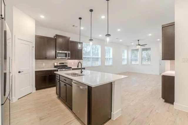 a kitchen with kitchen island a sink stainless steel appliances and cabinets