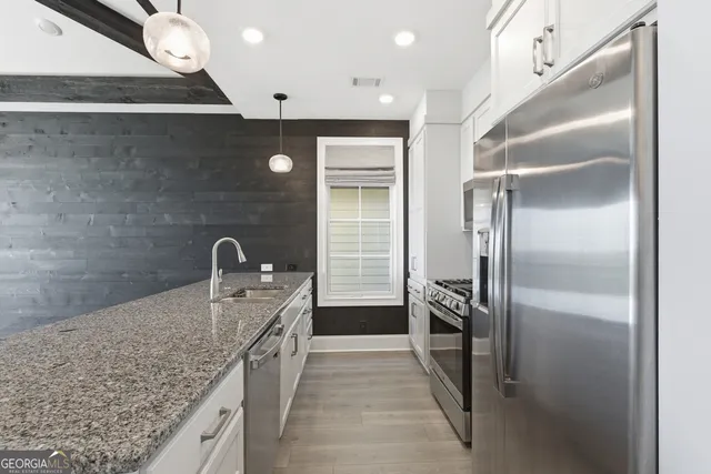 a kitchen with stainless steel appliances granite countertop a refrigerator and a sink