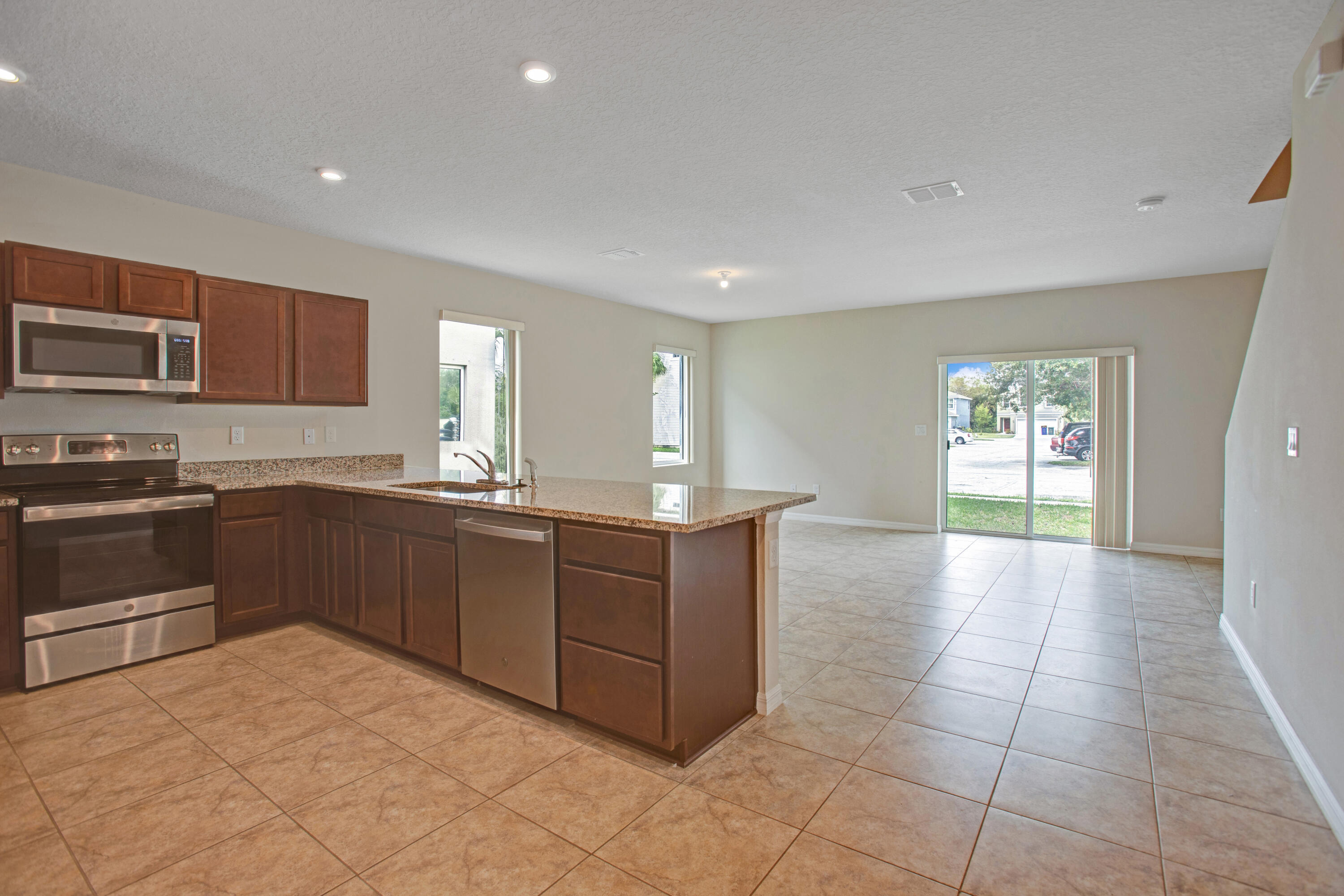 3343 Liberty Square Way, Unit 104 Fort Pierce, FL 34982 - Photo 6 of 34 a kitchen with stainless steel appliances granite countertop a stove and a sink