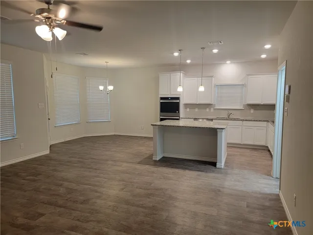 a view of kitchen with kitchen island stainless steel appliances sink cabinets and stove