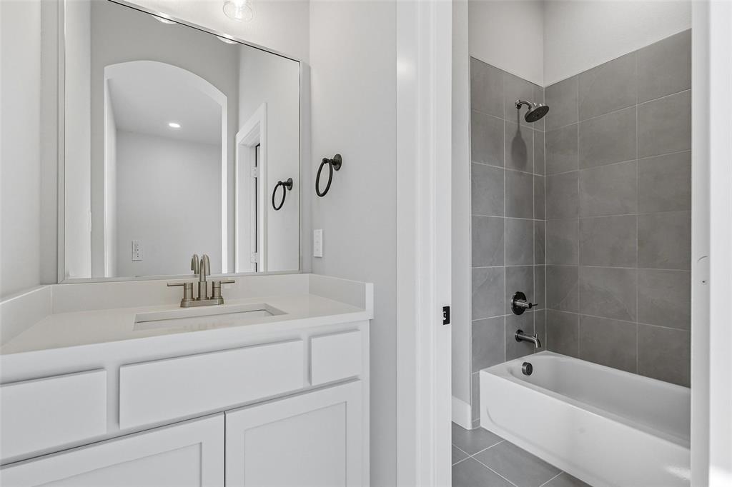 1005 Ronnie Court Springtown, TX 76082 - Photo 23 of 27 Full bath with vanity, dark tile patterned flooring, and shower / tub combination