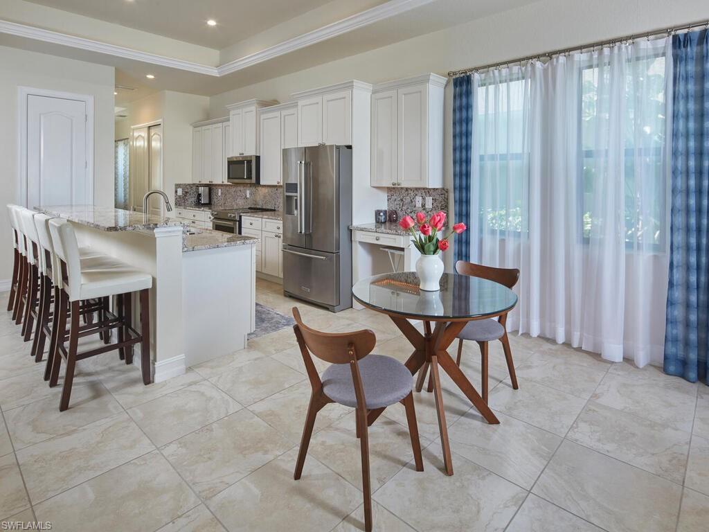 1119 Ridge Street Naples, FL 34103 - Photo 9 of 22 a dining area with furniture and a refrigerator