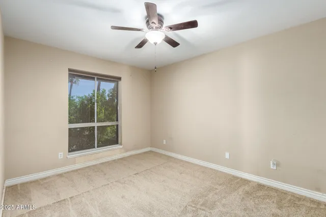 an empty room with a chandelier fan and a chandelier fan