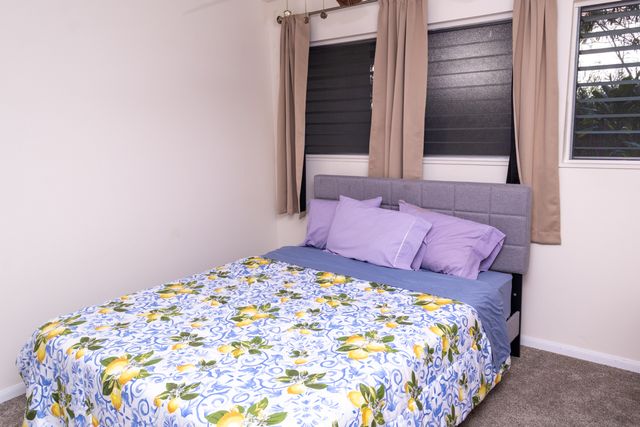 a large bed in a bedroom next to a window