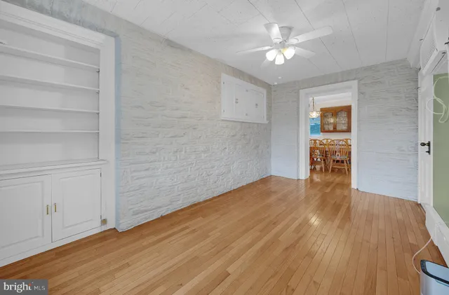 a view of a livingroom with wooden floor and a ceiling fan