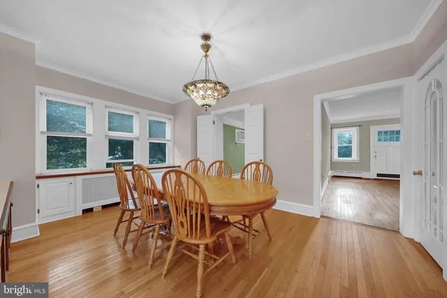 a dining room with furniture a chandelier and wooden floor