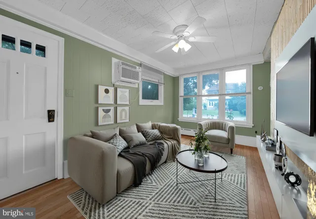 a living room with furniture a flat screen tv and a large window