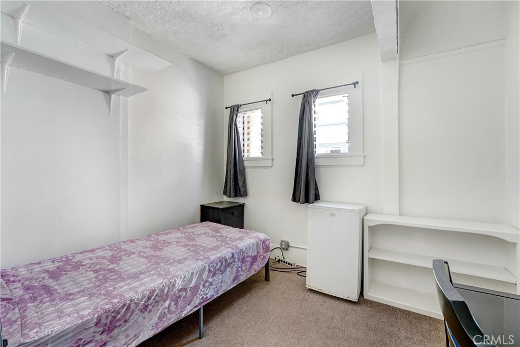 1041 Elden Avenue Los Angeles, CA 90006 - Photo 11 of 25 a bedroom with a bed a mirror and window