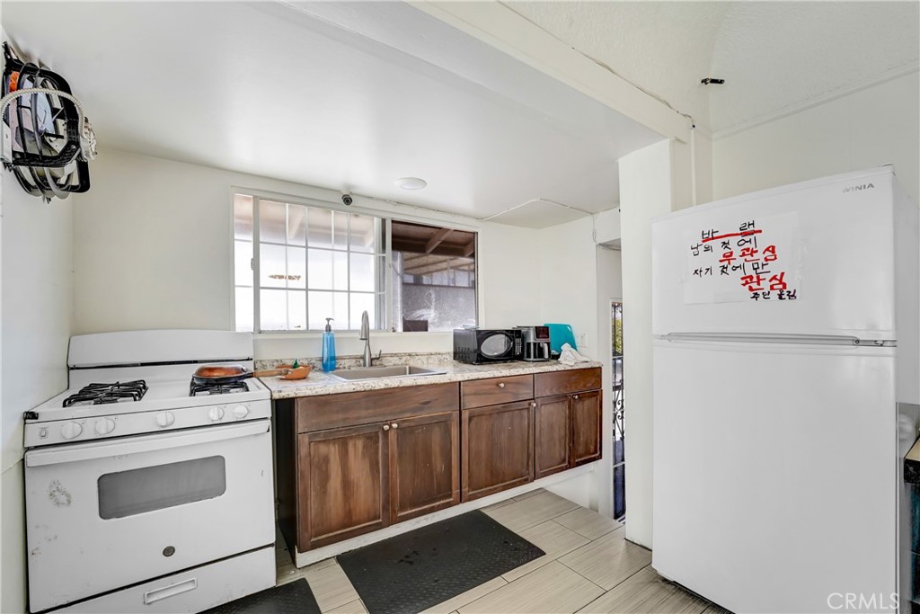 1041 Elden Avenue Los Angeles, CA 90006 - Photo 8 of 25 a kitchen with a stove and white cabinets