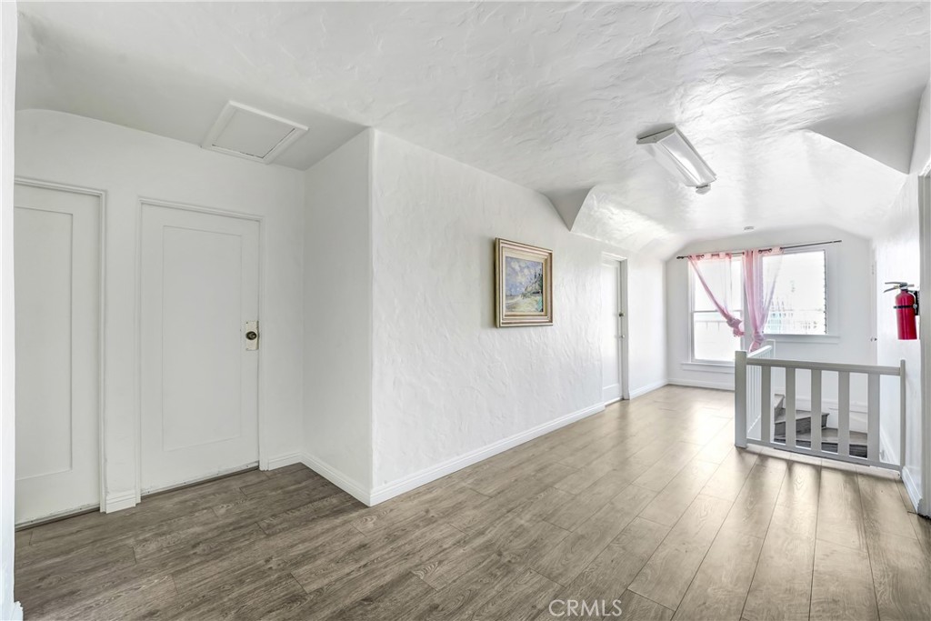 1041 Elden Avenue Los Angeles, CA 90006 - Photo 9 of 25 an empty room with wooden floor and windows
