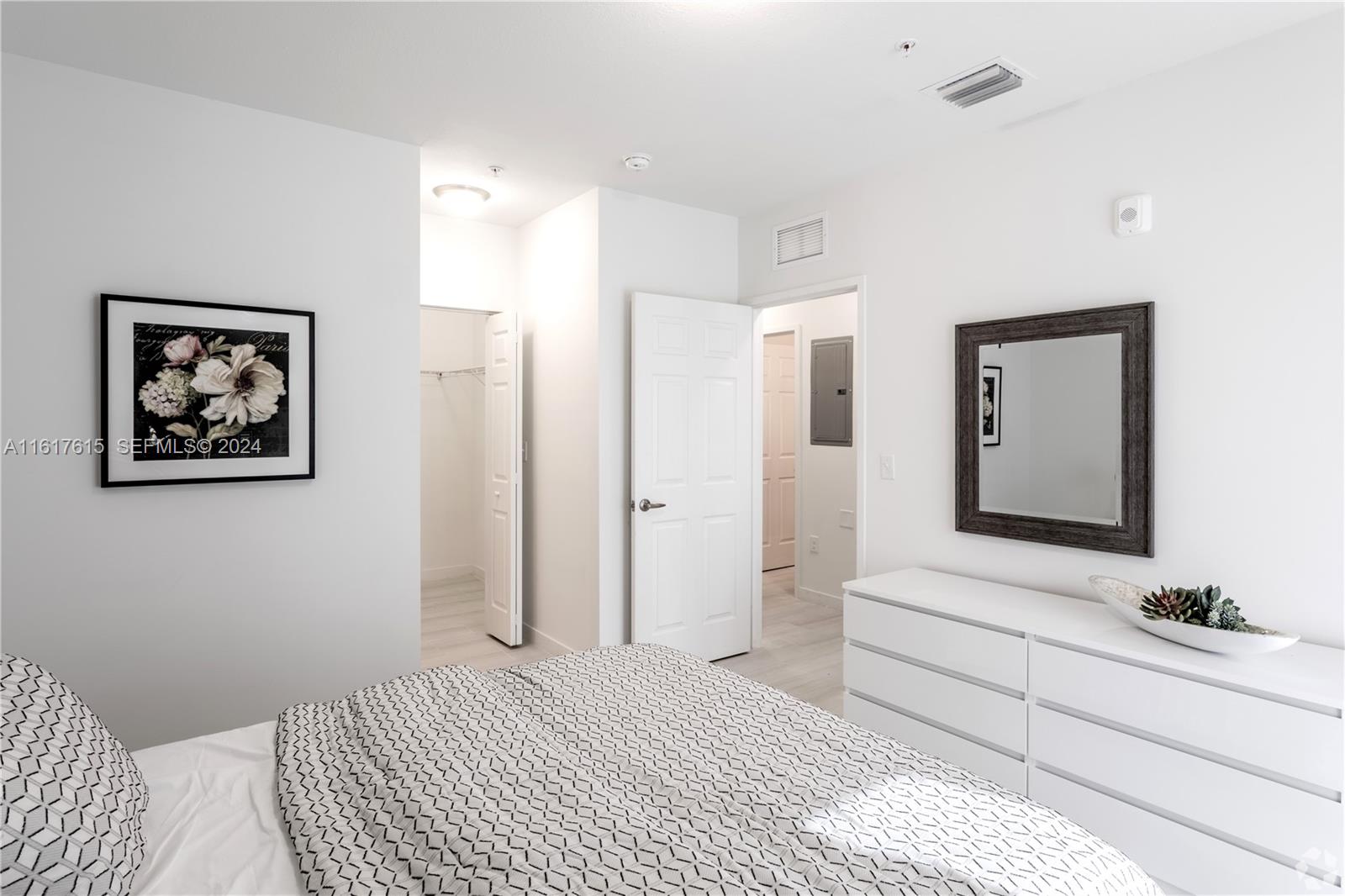 243 West 77th Street, Unit 102 Hialeah, FL 33014 - Photo 5 of 7 a bedroom with a large bed and a chandelier