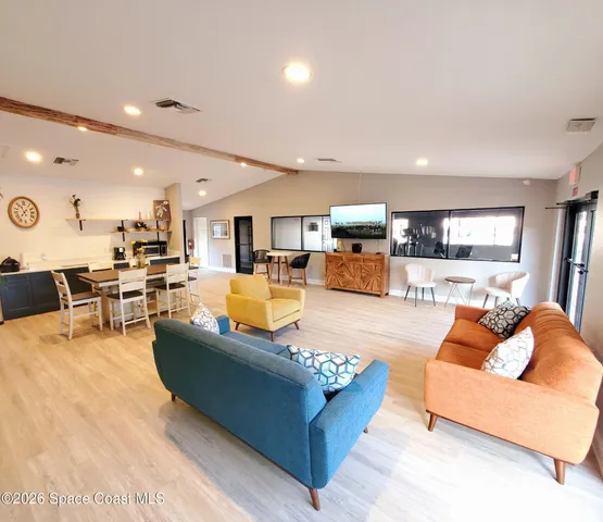 a living room with furniture and view of kitchen