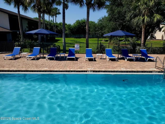 a view of a swimming pool with lounge chairs in patio